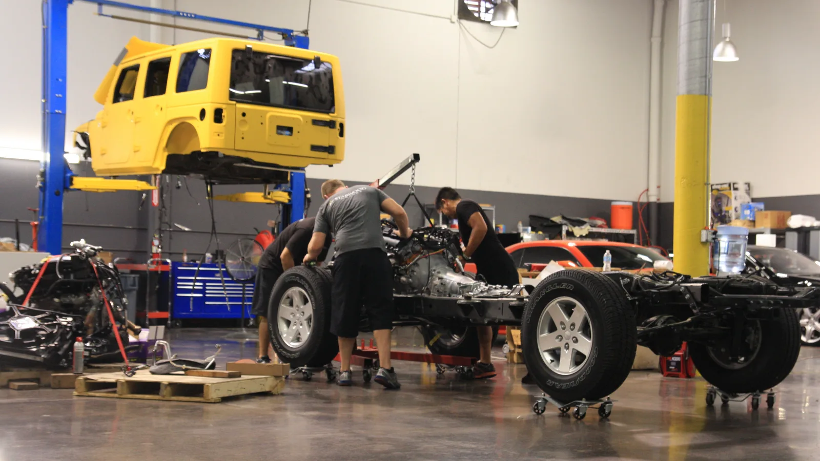 Technicians working on a Jeep Wrangler chassis and body during an upfit build at Starwood Motors