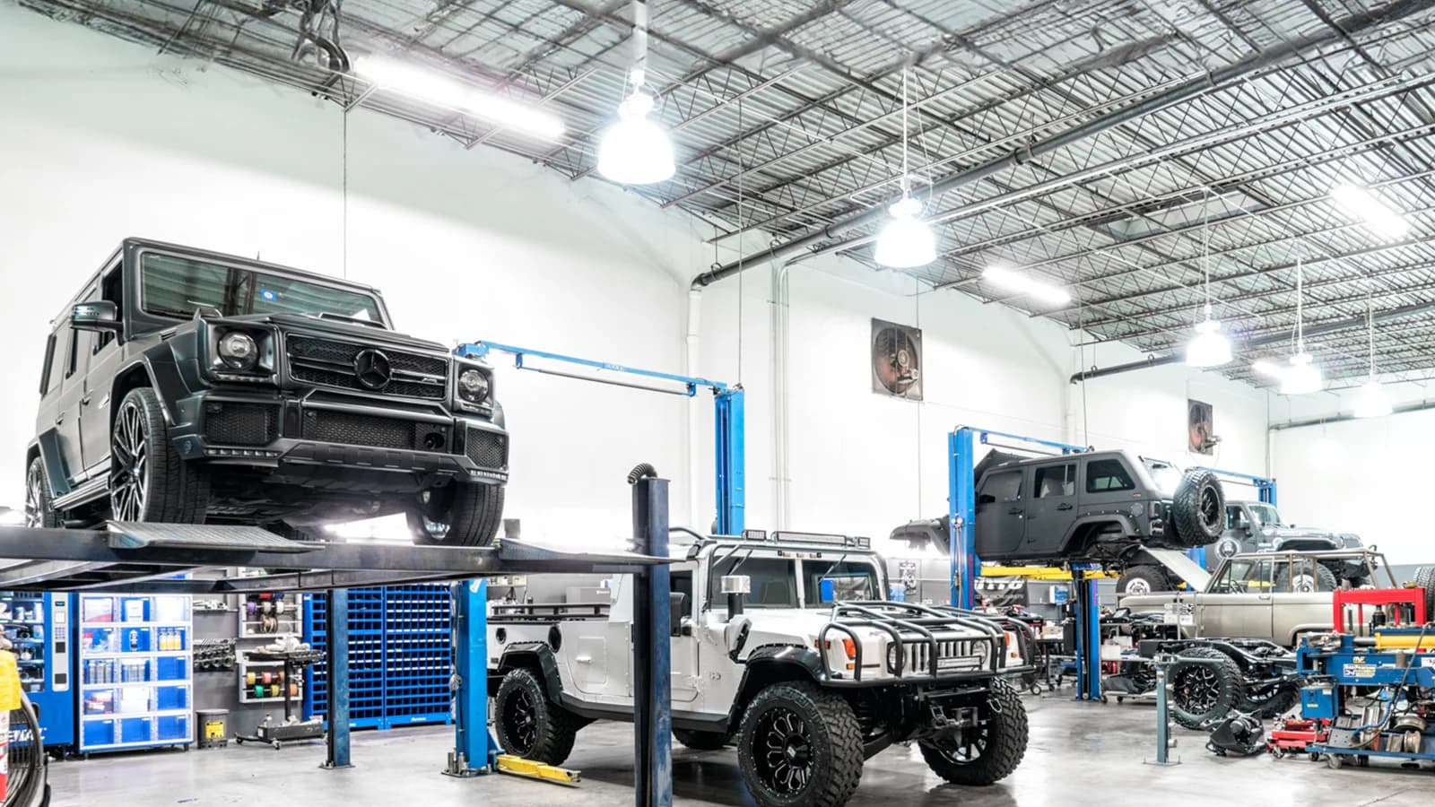 A dealership service floor with vehicles raised on lifts